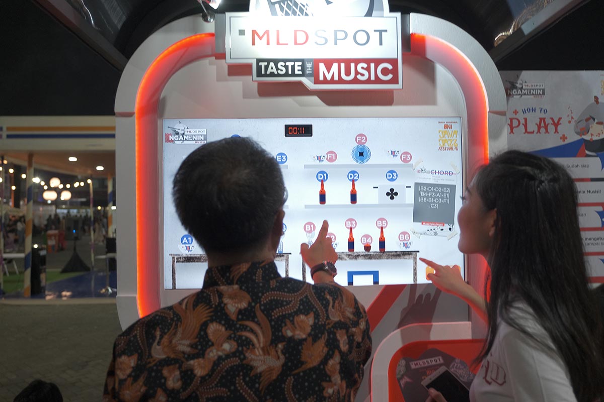 Pengunjung mencoba bermain di booth ‘Ngamenin Musisi’