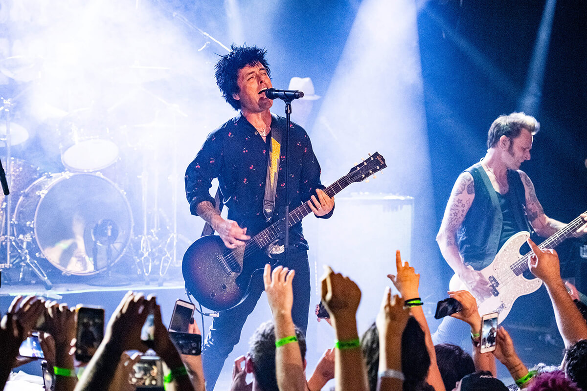 Billie Joe Armstrong, bersama anggota band Green day lain, tampil bernyanyi dan bermain gitar di sebuah event