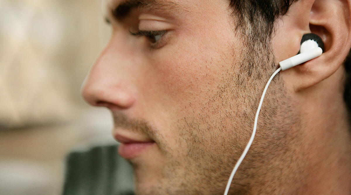 Seorang pria menggunakan in-ear headphone