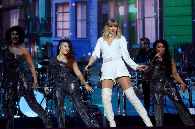 Penampilan Taylor Swift dengan penari latar dengan oufit all-white