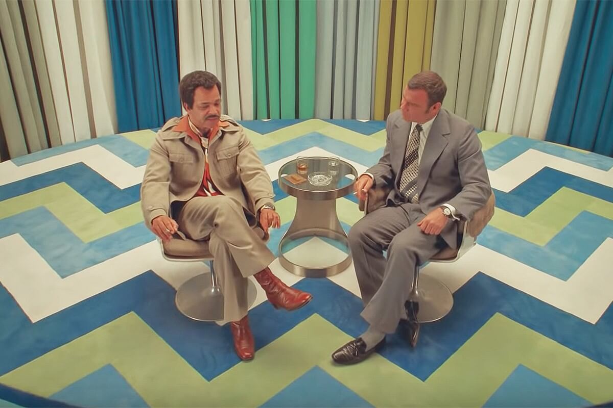 Dua pemeran sedang berdiskusi dalam talkshow, sebuah scene di French Dispatch